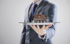 man holding house on tray